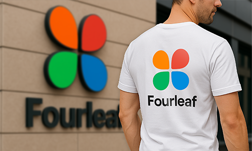Man wearing personalized white t-shirt with colorful “Fourleaf” logo matching branding on building wall in background.