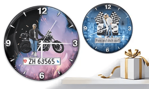 Zwei Wanduhren mit Fahrzeugmotiven: links mit Motorrad und violett-orangener Leuchtkulisse, rechts mit weißen Autos und Rennflaggen auf blauem Hintergrund