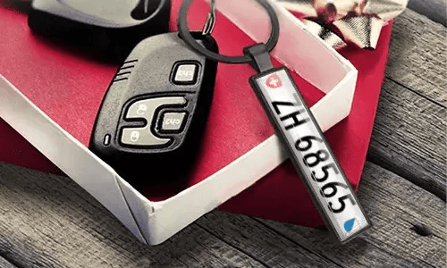Metalowy brelok z tablicą rejestracyjną pokazuje wygrawerowane numery obok kluczy samochodowych