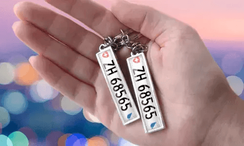 Porte-clés avec plaque personnalisée et numéros personnalisés, tenu en main