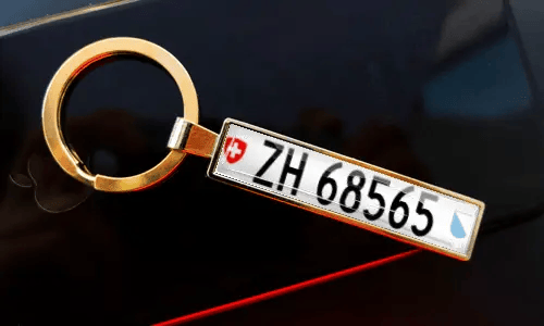 Nummernschild-Schlüsselanhänger an Schlüsseln in der Tasche, mit Auto im Hintergrund