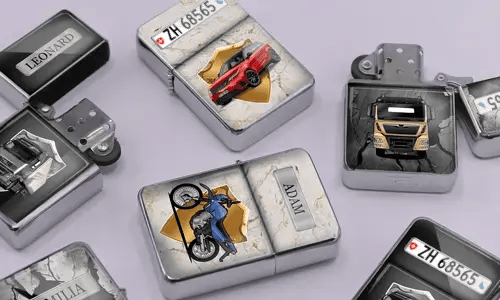 A variety of metal lighters lie on a soft purple surface, featuring personalized designs of cars, motorcycles, and trucks, each marked with different names.