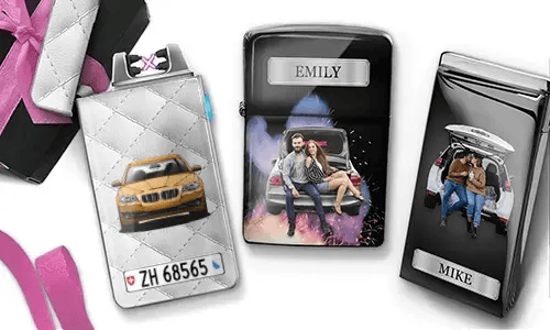 Drei personalisierte Zigarettenetuis sind zu sehen. Das erste zeigt ein Auto mit Kennzeichen. Das zweite zeigt ein Paar, das auf einem Auto sitzt, mit der Aufschrift „Emily“ vor farbenfrohem Hintergrund. Das dritte zeigt ein Paar im Kofferraum eines Autos, mit der Aufschrift „Mike“. Rosafarbene Schleifenakzente sind sichtbar.