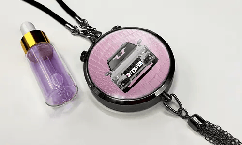 Pendant with pink background and white sports car, next to purple dropper bottle with gold cap