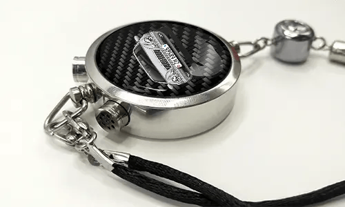 Round car key fob with carbon fiber face, buttons labeled LOCK and UNLOCK, braided black cord attached