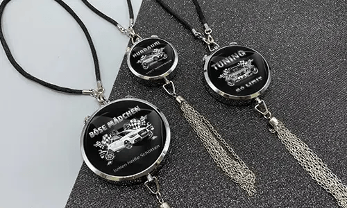 Three black pendants with chains: each with car graphic and German tuning slogan on glittery surface