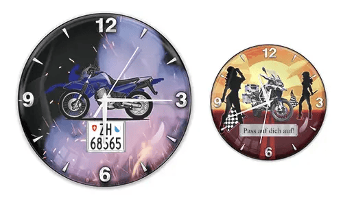 Zwei Wanduhren mit Motorradmotiven: links mit blauem Bike und Flammenhintergrund, rechts mit weißem Bike und Sonnenuntergang