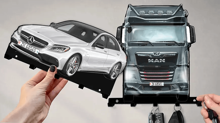 Wall-mounted key holder with detachable white Mercedes-Benz and black MAN truck shapes, each with hooks for keys