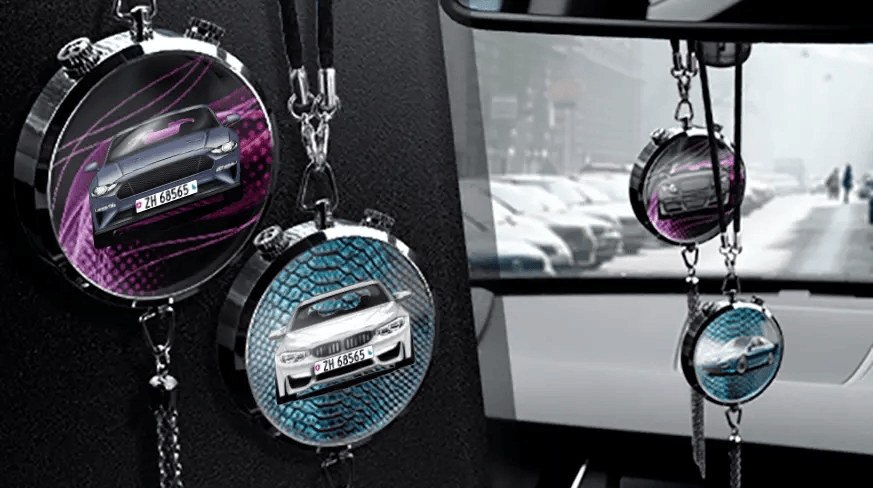 Two circular car air fresheners hanging from rearview mirror: left with black car, right with blue car